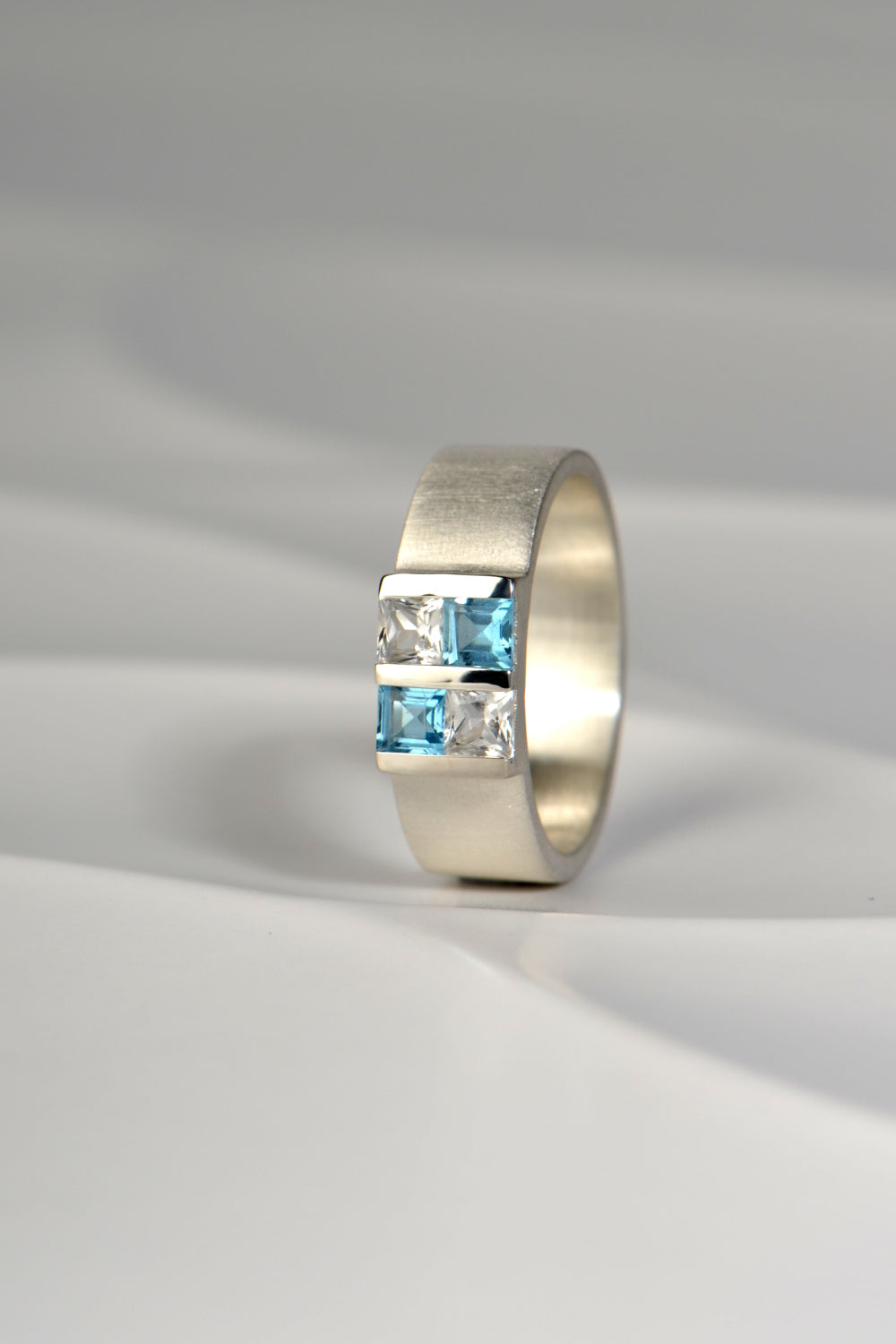 Battenberg ring with blue and white topazes