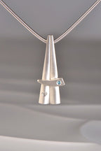 contemporary stacking pendants in brushed sterling silver that are inspired by Scottish Cairns by Christine Sadler. One is set with a diamond and the other with a blue topaz.