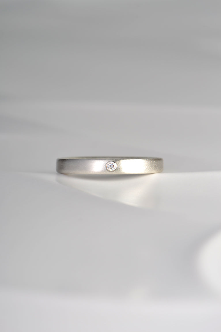 modern plain silver ring set with a diamond and matt finished