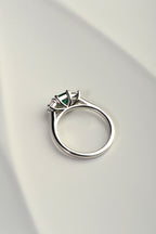 side view of emerald and diamond engagement ring showing the sweeping angles that allows a wedding ring to snuggle fit next to it. Exclusively from UK jewellery designer Christine Sadler