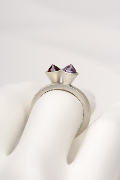 two silver rings stacked together with an amethyst and a garnet gemstone by british jewellery designer Christine Sadler