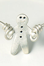 smiling silver gingerbread man with black diamonds that looks like he is skipping with silver wire to form a cute bangle - British jewellery designer Christine Sadler