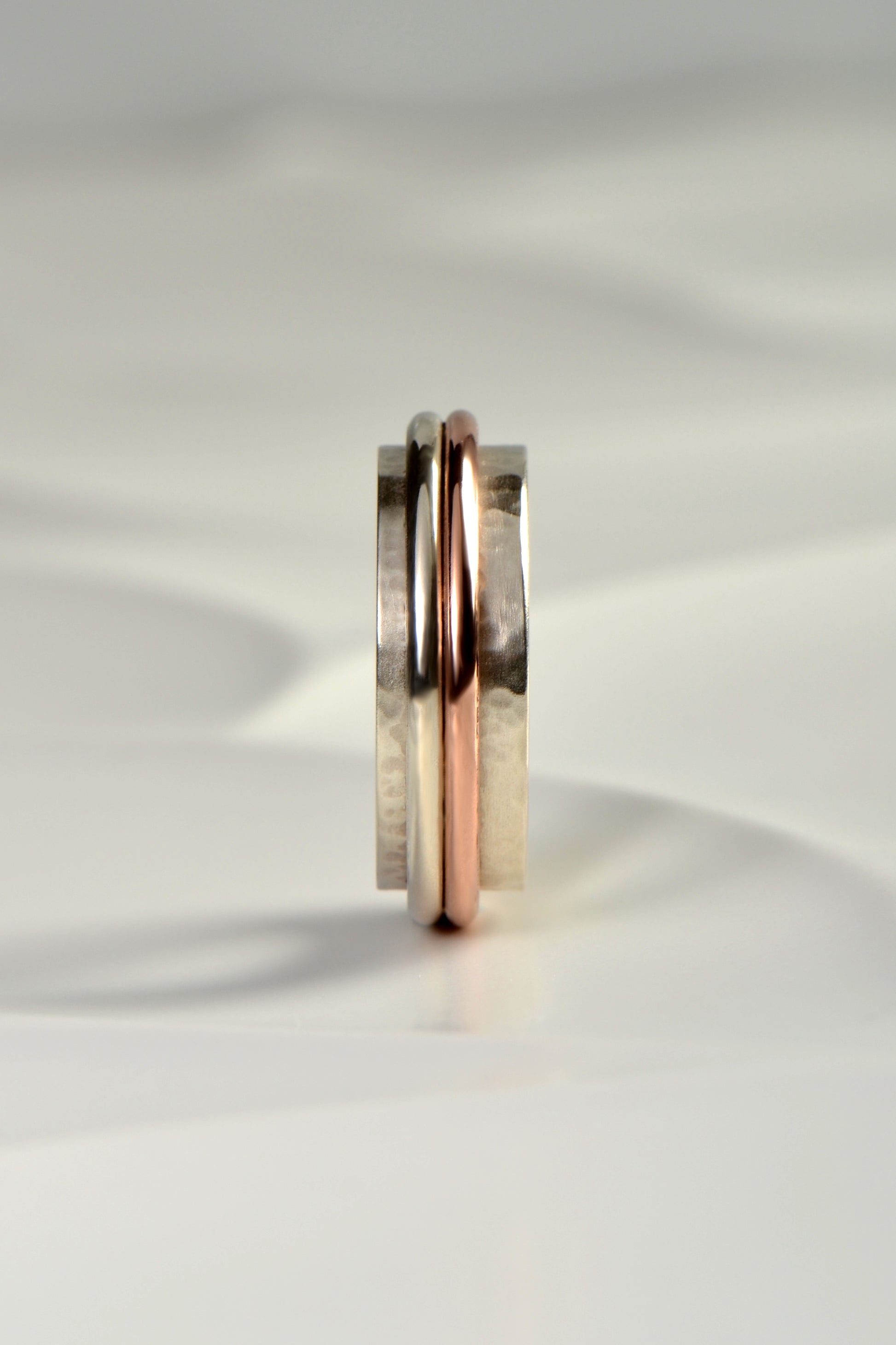 chunky handmade sterling silver hammer textured ring for a man with a rose gold detail from Christine Sadler