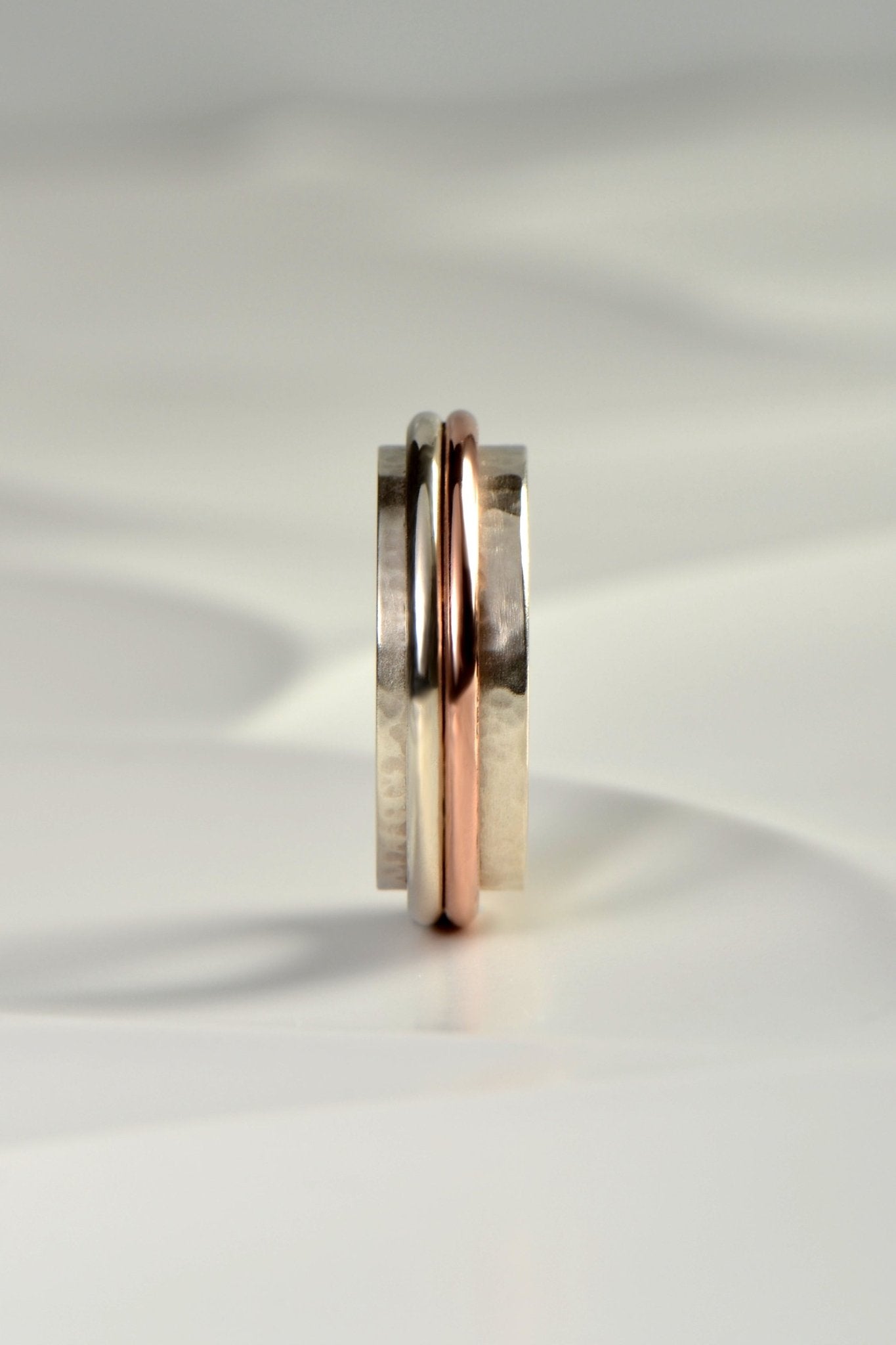 chunky handmade sterling silver hammer textured ring for a man with a rose gold detail from British jewellery designer Christine Sadler