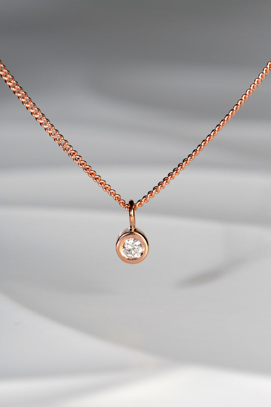 Handmade 9ct rose gold petite diamond necklace. The pendant measures 5mm in diameter and the diamond measures 3mm in diameter. The necklace is designed by british jewellery designer Christine Sadler and made in her workshop in Ayr