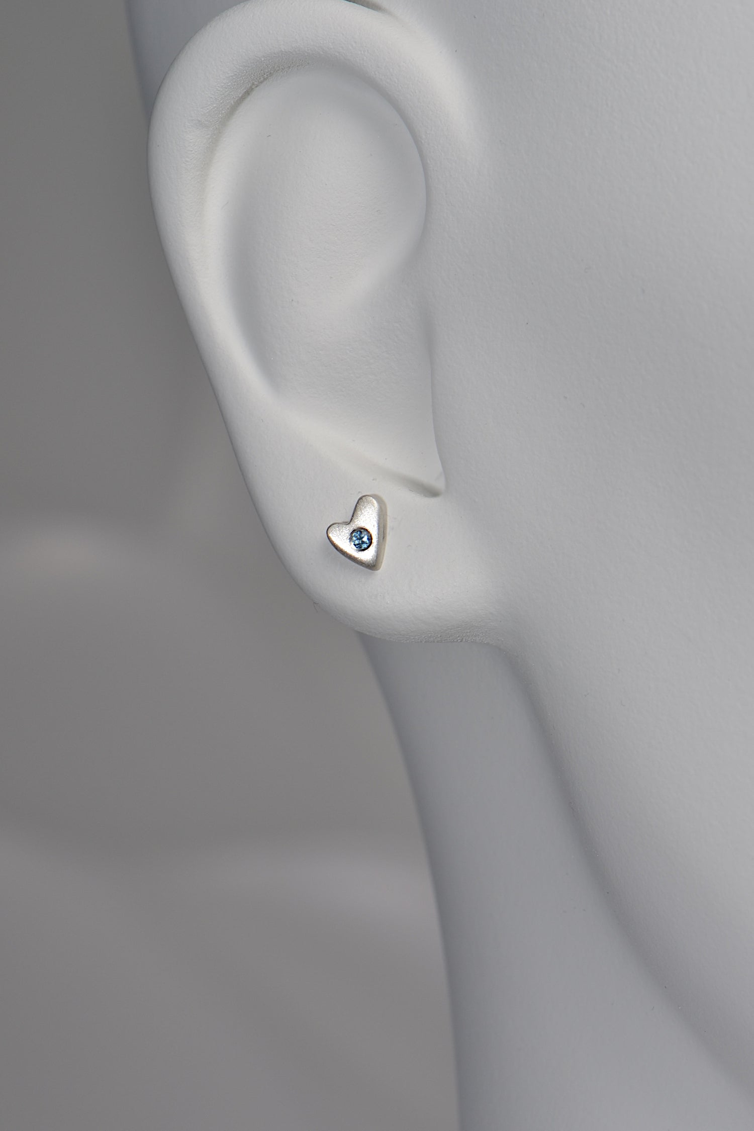 From the Heart aquamarine earrings in matt silver shown on a white mannequin for size and scale