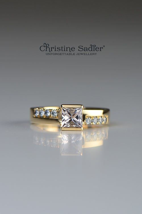 18ct yellow gemstone ring set with a square morganite in a very contemporary setting with 8 round brilliant cut diamonds set into the band, 4 on each side of the morganite in an asymmetric pattern.
