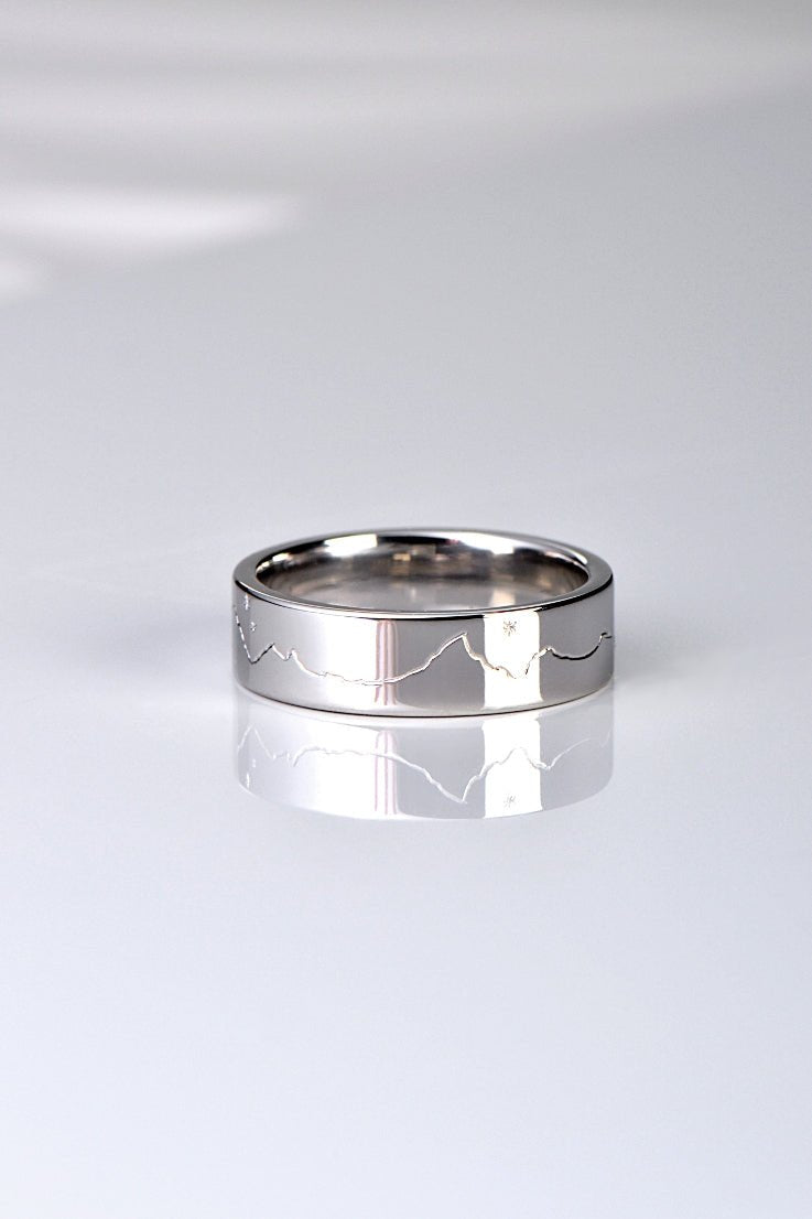 different and special wedding ring design hand engraved with a mountain range and a moon and stars