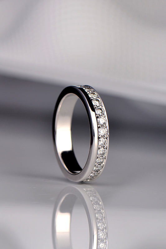 modern diamond set wedding ring for a woman that has the diamonds along one edge or the ring rather than in the middle from Christine Sadler
