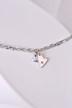 delicate modern silver heart bracelet handmade and set with a pink sapphire