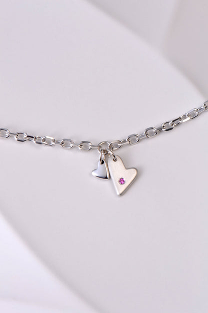 delicate modern silver heart bracelet handmade and set with a pink sapphire
