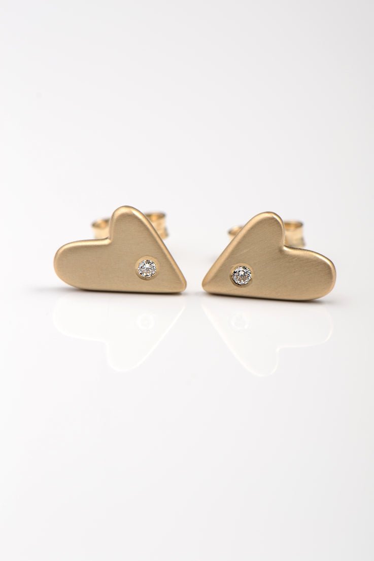 handmade large real gold heart stud earrings with a diamond in each one on a white background