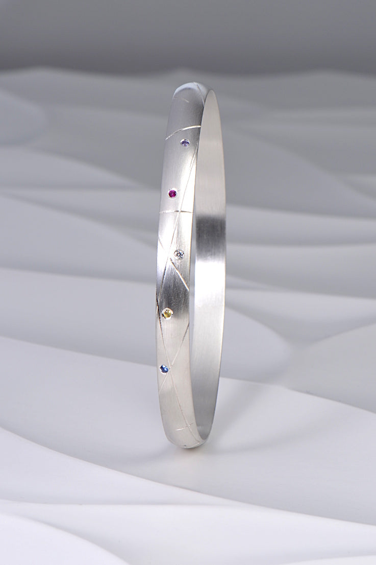 hundreds and thousands or sprinkles handmade silver bangle set with coloured sapphires and a diamond from Christine Sadler's afternoon tea jewellery collection