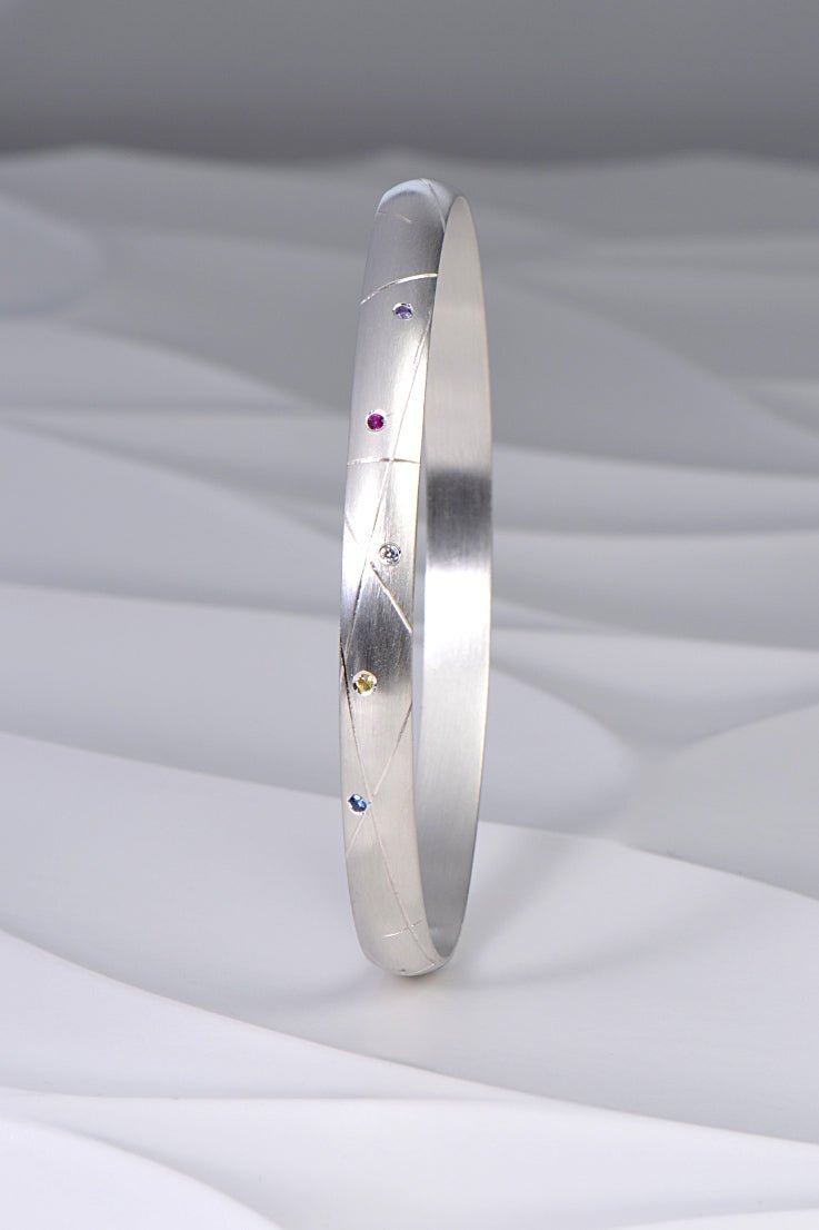 hundreds and thousands or sprinkles handmade silver bangle set with coloured sapphires and a diamond from Christine Sadler's afternoon tea jewellery collection