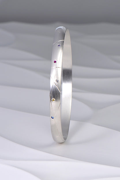 hundreds and thousands or sprinkles handmade silver bangle set with coloured sapphires and a diamond from Christine Sadler's afternoon tea jewellery collection