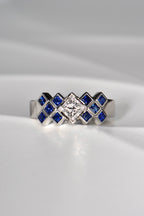 Princess cut diamond ring set with square blue sapphires in a tartan pattern. This Scottish ring is made of platinum and is a unique copyrighted design. 