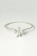 handmade silver bangle that is a gingerbread man set with black diamonds skipping with silver wire. British jewellery designer Christine Sadler