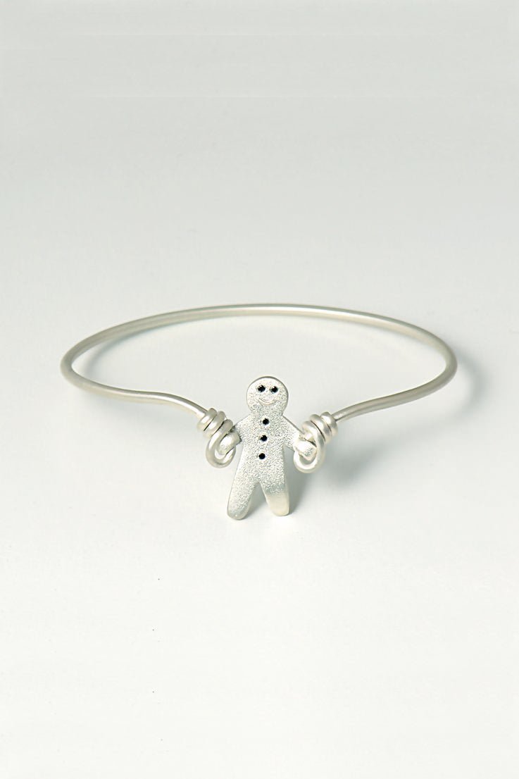 handmade silver bangle that is a gingerbread man set with black diamonds skipping with silver wire. British jewellery designer Christine Sadler