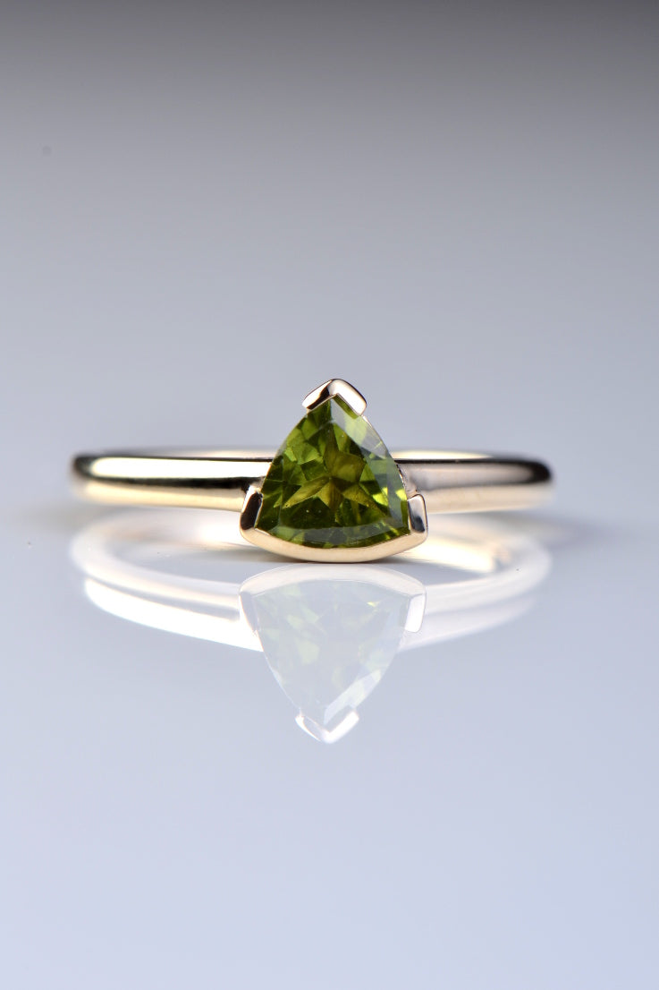 Slingshot peridot trillion ring in 9ct yellow gold