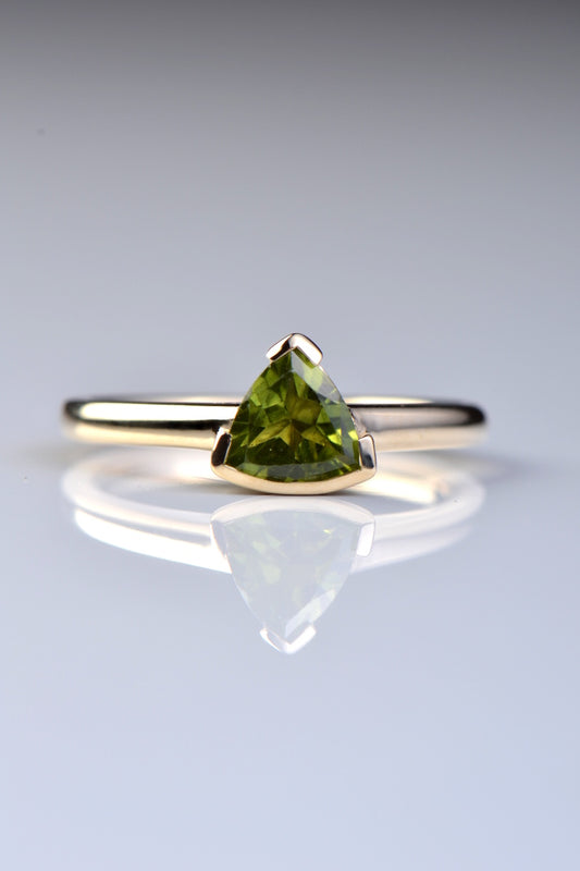 Slingshot peridot trillion ring in 9ct yellow gold