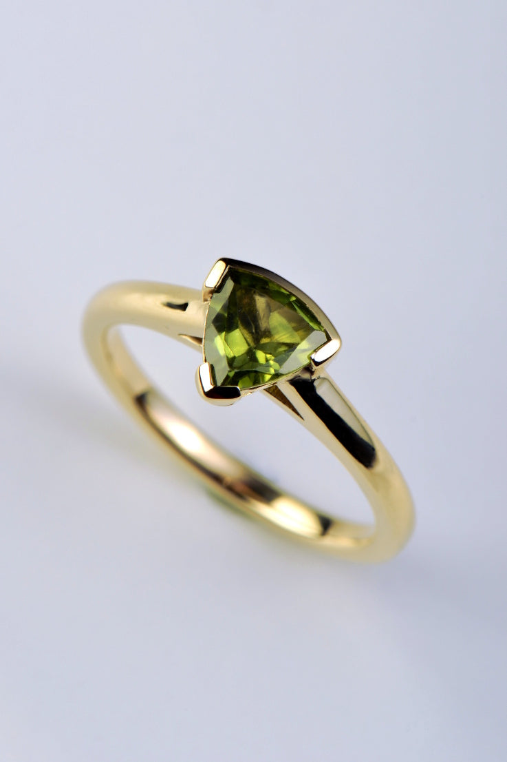 Slingshot peridot trillion ring in 9ct yellow gold