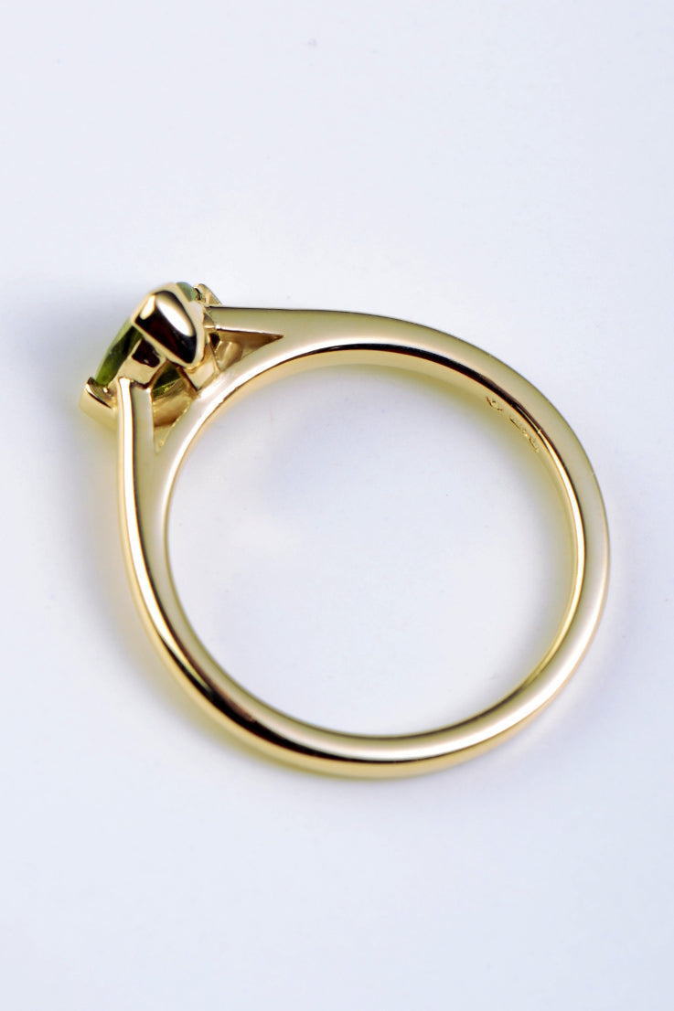 Slingshot peridot trillion ring in 9ct yellow gold