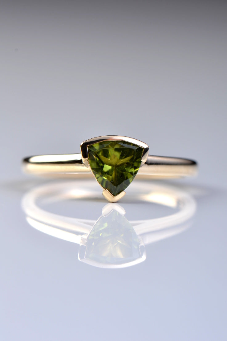 Slingshot peridot trillion ring in 9ct yellow gold