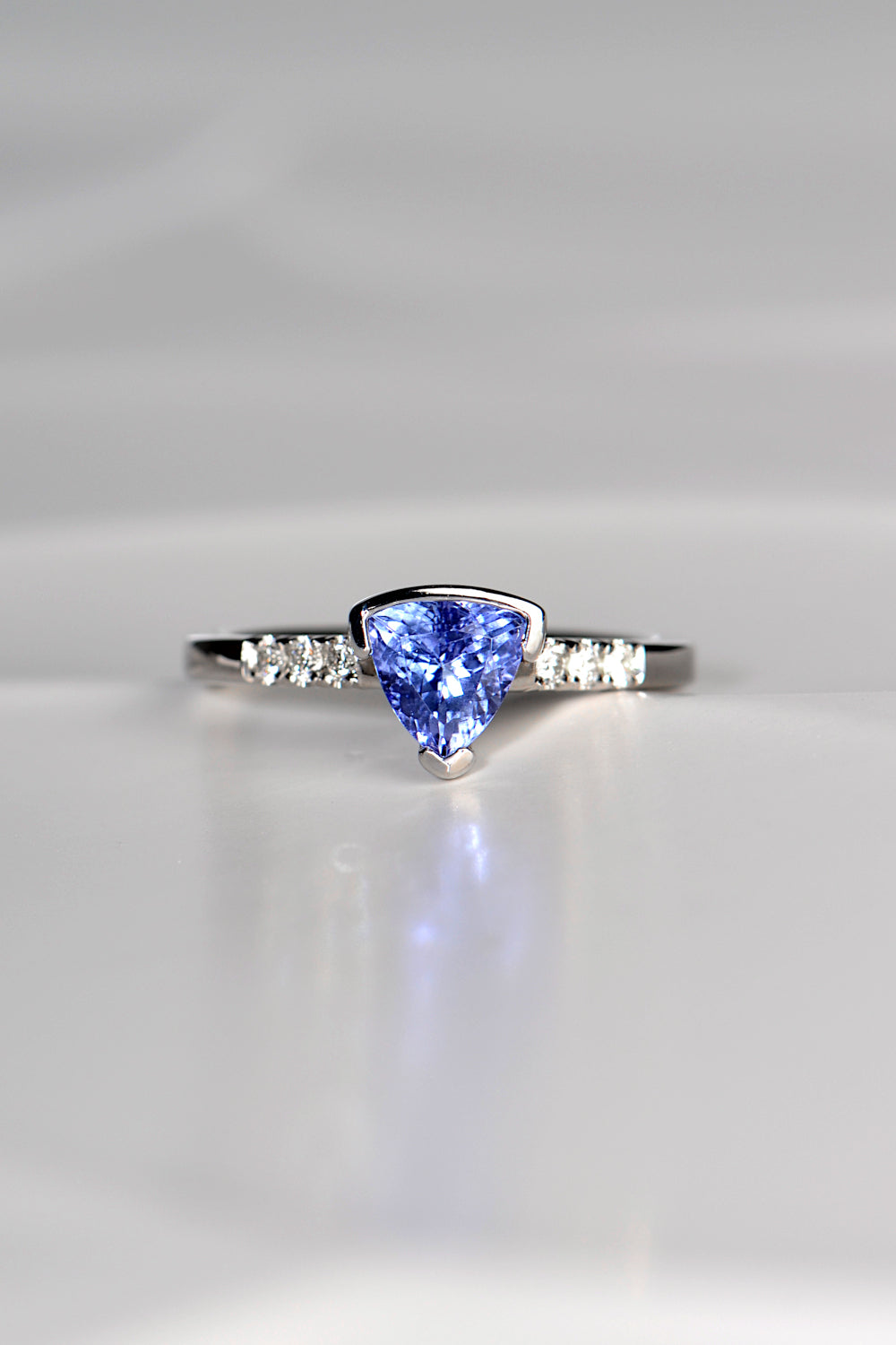 trillion cut tanzanite ring with three diamonds on either side exclusively available from fine jewellery designer Christine Sadler
