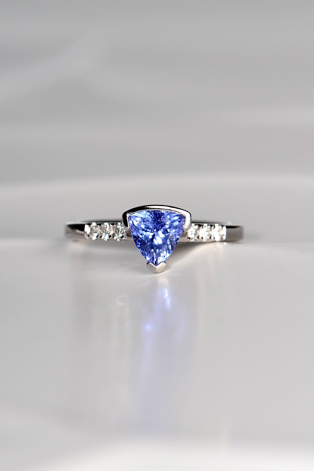 trillion cut tanzanite ring with three diamonds on either side exclusively available from fine jewellery designer Christine Sadler