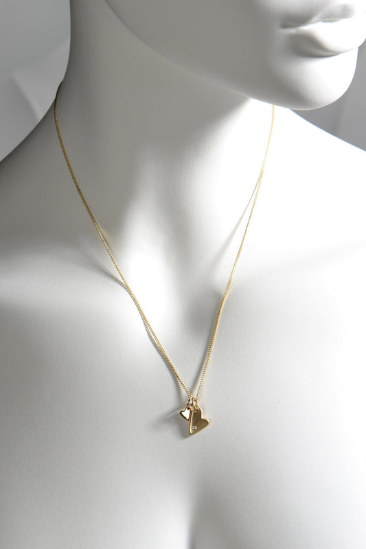 9ct yellow gold double heart necklace with diamond, brushed and polished finishes on 45cm curb chain  shown on a white mannequin to show size and scale — From The Heart collection by Christine Sadler