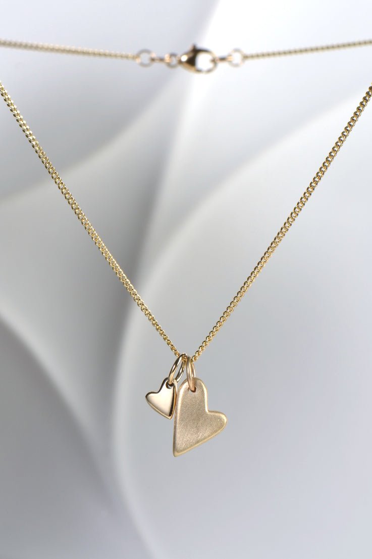 9ct yellow gold double heart necklace with brushed and polished finishes on a 45cm curb chain from the From The Heart collection by Christine Sadler