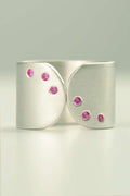 unique wide silver ring with pink sapphires set to look like the patterns on dessert plates at Michelin star restaurants by contemporary jewellery designer Christine Sadler